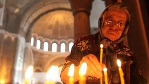 A woman lights candles at St. Sava temple during mass prayers for Kosovo in Belgrade July 22, 2010