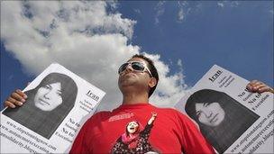 A protester hold placards with Ashtiani's pictures in London