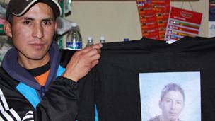 Carlos Olivo holds a T-shirt imprinted with his brother's picture