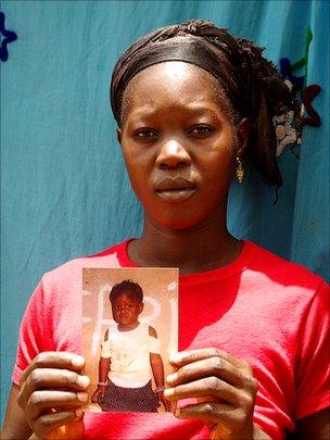 Hawa Camera holding a photo of her daughter who is missing