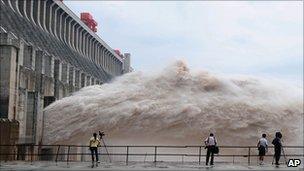 Journalists film as water is released from the Three Gorges Dam in Yichang, China (20 July 2010)