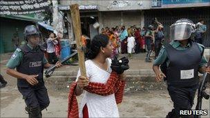 A garment worker holds a wooden stick during a protest in Dhaka in June 2010