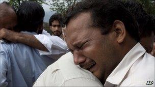 Relatives mourn the deaths of their family members killed in a plane crash, outside a local hospital in Islamabad, Pakistan