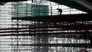 A construction worker works on the Aquatic Centre at the London 2012 Olympic site in Stratford, east London