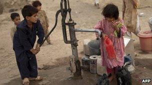 Pakistani children pump water from a well in the capital, Islamabad - 21 June 2010