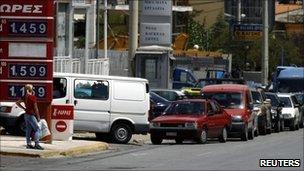 Cars line up at a petrol station in Athens on 28 July 2010