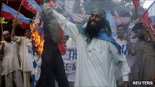 Supporters of Shabab-e-Milli burn an effigy of David Cameron in Karachi 31 July 2010