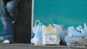 Man alongside plastic shopping bags