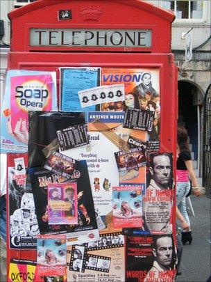 high street telephone box covered in posters