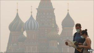 People wear face masks to protect themselves from the forest fire smog in Moscow on August 4, 2010