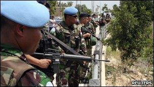 Lebanese soldiers and U.N. peacekeepers stand at the Lebanese-Israeli border