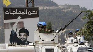 Unifil vehicles patrol in front of a picture of Hezbollah leader Hassan Nasrallah in the southern border village of Adaisseh, Lebanon, August 4, 2010.