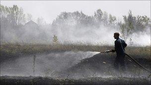 A Russian firefighter works to extinguish dry grass burning near the town of Voronezh, 500 km (294 miles) south of Moscow