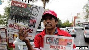 A newspaper vendor holds local newspapers with front page stories about the death of Ignacio "Nacho" Coronel, a major Mexican drug trafficker, in Guadalajara 30 July 2010.