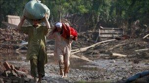 Family members salvage belongings from their destroyed house in Pabbi, located in Pakistan"s northwest Khyber-Pakhtunkhwa