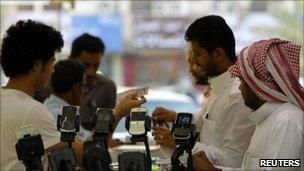 Men stand near BlackBerry phones on sale at a shopping mall in Riyadh