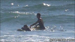 One of Freshwater West's lifeguards helping one of the rip current victims to safety (RNLI/Adam Pitman)