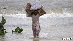 Man in flood waters in the Muzaffargarh district of Punjab province