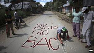 Protester writes anti-Indian graffiti on a road