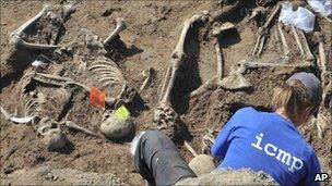 A forensic expert examines the remains of bodies believe to be victims of the Visegrad massacre