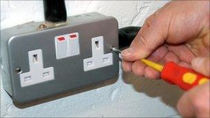 Electrician mending plug socket