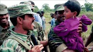 Tamil Tiger soldiers hold a child. File photo