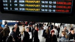 People stand in front of an information board in the departure hall of Sofia airport