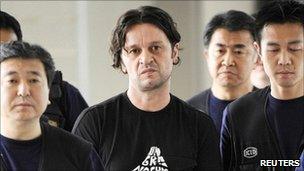 Suspect Rifat Hadziahmetovic (centre) is escorted by Japanese authorities at Narita international airport, east of Tokyo. Photo: August 2010