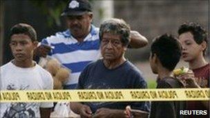 Salvadorans looking at a crime scene on 21 June 2010