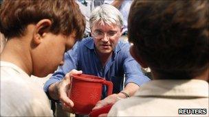 Andrew Mitchell and two flood survivors in Nowshera in Pakistan on 18 August