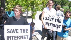 people holding save the internet signs