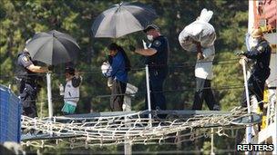 Migrants escorted off the MV Sun Sea after they arrived in Canada