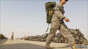 A US soldier from the 1st Battalion, 116th Infantry Regiment, carries his bag as he prepares to pull out from Iraq to Kuwait, at Tallil Air Base near Nassiriya, on 15 August 2010.