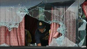 A Philippine forensic expert examines the bus in Manila on 24 August 2010