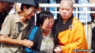 Buddhist monk comforts grieving family members in Manila