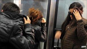 Members of the Roma community hide their faces as they arrive at Sofia airport, Bulgaria, after being expelled from France