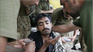 A flood victim receives help at an army relief camp in Punjab province, Pakistan, 25 August 2010