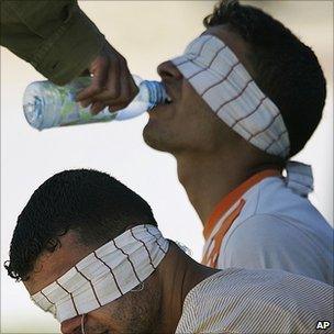 Israeli soldier gives Palestinain prisoner a drink of water