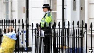 A police officer outside the flat in Pimlico, London