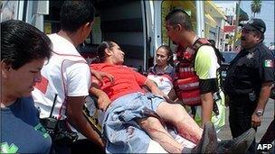 An injured man is taken onto an ambulance in Reynosa, Mexico