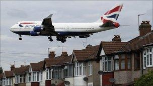 A plane flies over homes in west London