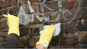 People washing graffiti in community payback scheme