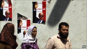 Egyptians walk by posters of Omar Suleiman in Giza, Cairo, 2 September