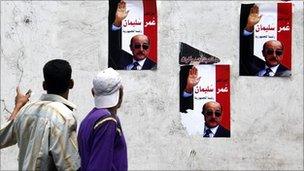 Egyptians walk by posters of Omar Suleiman in Giza, Cairo, 2 September