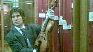 Darryl Martin, curator of the University of Edinburgh's musical instrument collection, holding the "Sherlock" violin