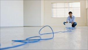 Man at computer at end of cable (Thinkstock)