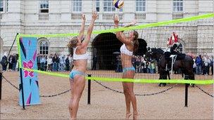 Lucy Boulton (left) and Denise Johns, members of the Team GB Beach Volleyball team, playing Beach Volleyball against a backdrop of the Household Cavalry Mounted Regiment Changing of the Guard, at Horse Guards Parade