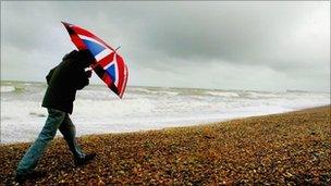 Man on beach with Union jack umbrella