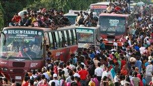 Passengers try to board buses at the Tongi bus station in Dhaka, Bangladesh