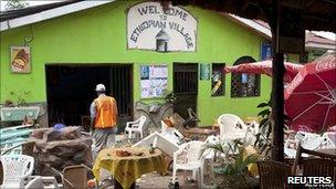 A rescue surveys the bomb damage to a restaurant in Kampala